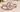 Round diamond engagement ring shown in a close-up view on a soft neutral background. 